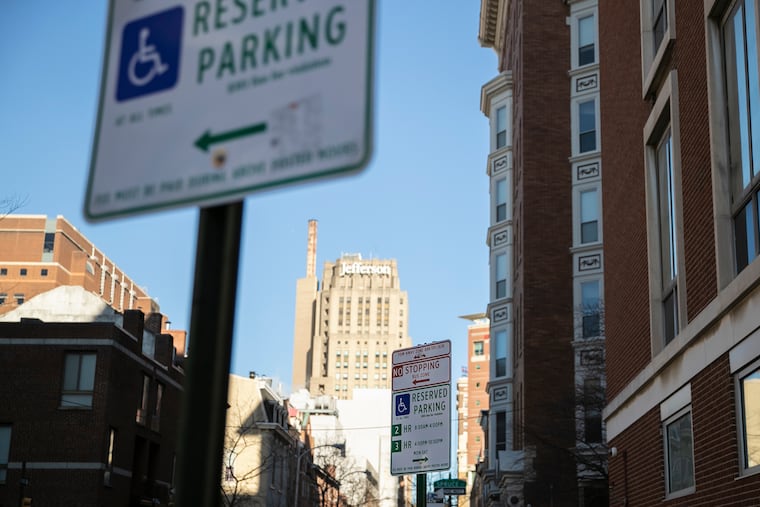 Handicap parking signs are photographed on the corner of Spruce and 9th Streets.