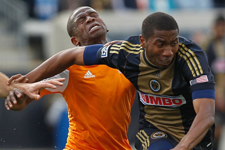 Union's Raymon Gaddis (right) fouls Dynamo's Oscar Boniek Garcia. (Ron Cortes/Staff Photographer)