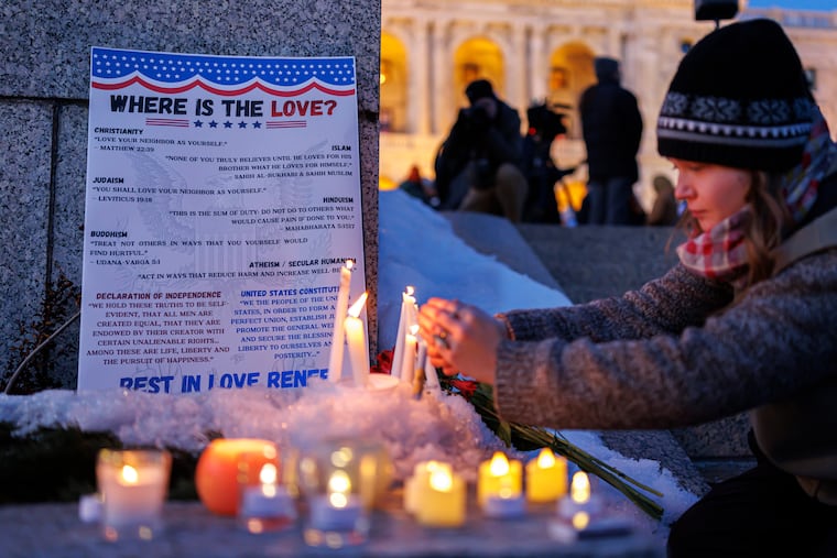 Candles burn around a poem written by Renee Good during a vigil honoring her on Friday, Jan. 9, 2026, in St. Paul, Minn., outside the Minnesota State Capitol.