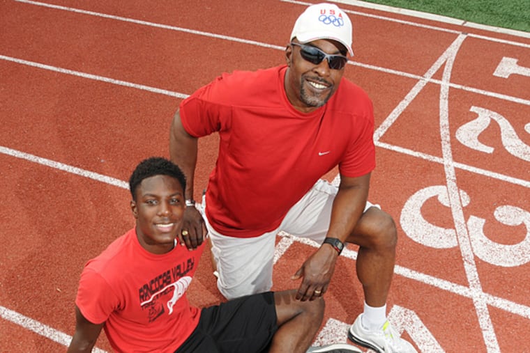 Rancocas Valley sprinter Sterling Pierce, , sitting, with his father, Olympic medalist Jack Pierce. On the track at RV in Mt. Holly. (Curt Hudson/Staff Photographer)