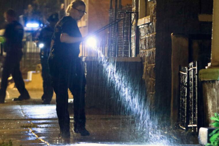 Police investigate the crime scene at Ogden Street near 41st, in West Philadelphia after seven people were shot, including three children. JOSEPH KACZMAREK/ FOR THE DAILY NEWS