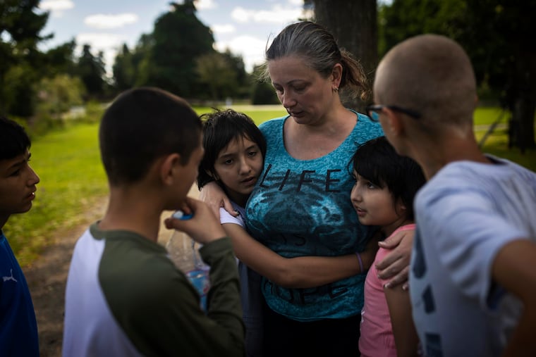 Olga Lopatkina embraces her adopted children in a park in Loue, western France, in July. After two months of negotiation and an initial objection from a senior Russian official, Donetsk People’s Republic authorities finally agreed to allow a volunteer with power of attorney from Lopatkina to collect her children who were evacuated from Mariupol.