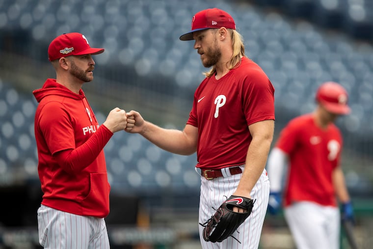 Phillies pitching coach Caleb Cotham fist bumps Noah Syndergaard during a recent workout at Citizens Bank Park.