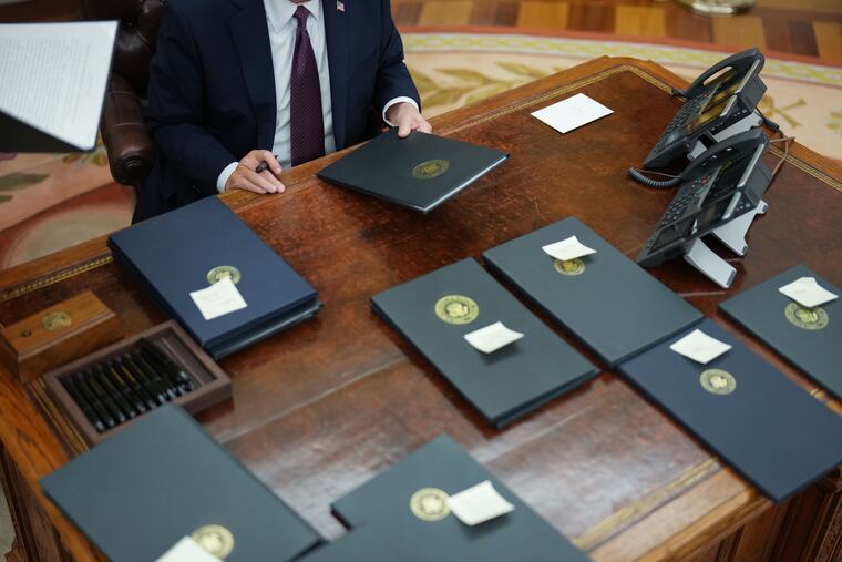 President Donald Trump signs executive orders in the Oval Office on Jan. 20, the day of his inauguration. MUST CREDIT: Jabin Botsford/The Washington Post