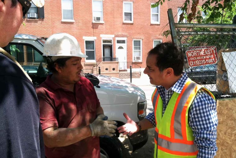 Nick DeJesse (right) talks to a construction worker at a South Philadelphia job site. DeJesse is Philadelphia director of the Occupational Safety and Health Administration.