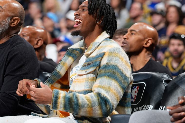 Philadelphia 76ers guard Tyrese Maxey, center, looks on from the bench in the first half of an NBA basketball game against the Denver Nuggets, Saturday, Jan. 27, 2024, in Denver. (AP Photo/David Zalubowski)