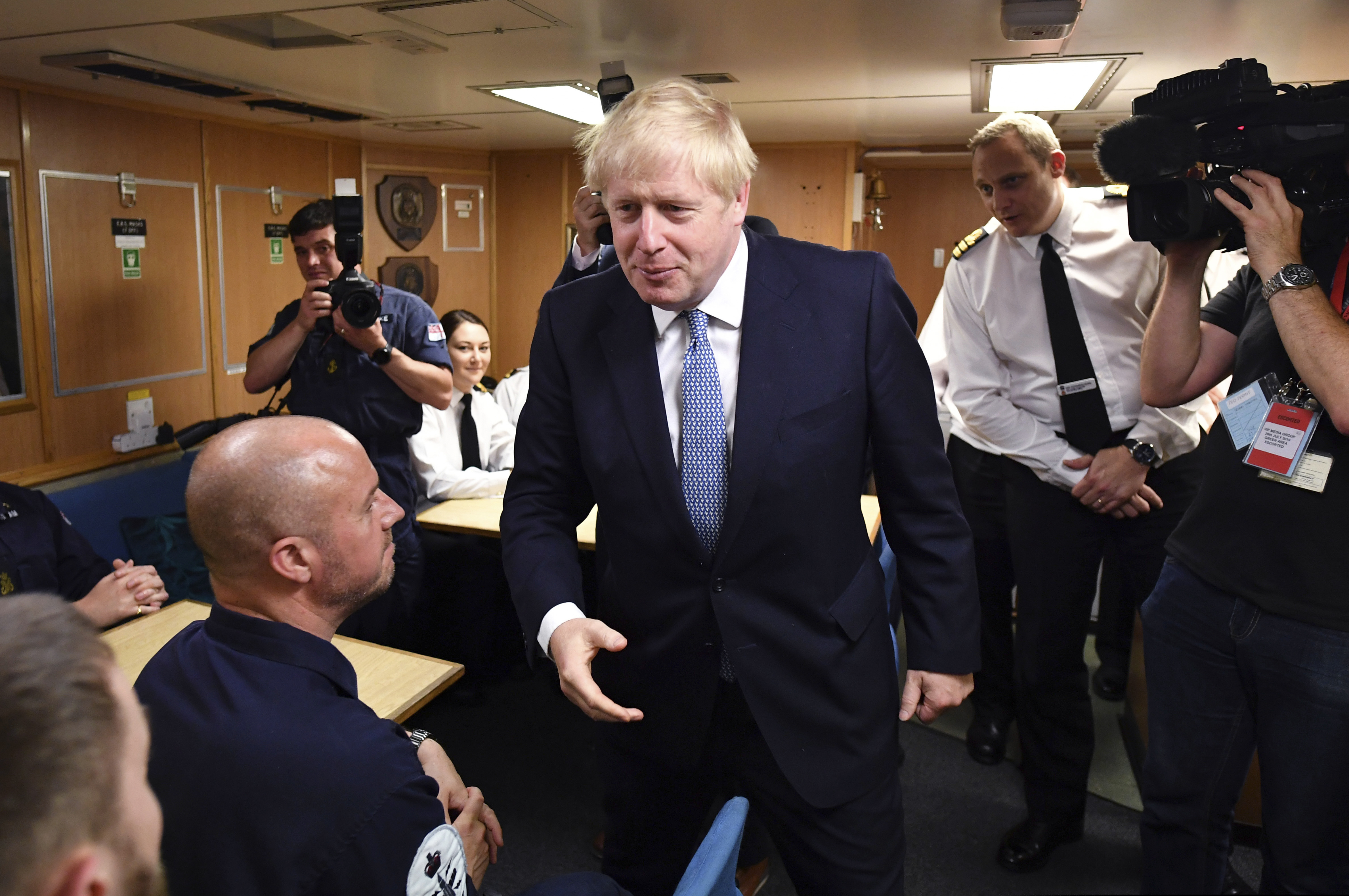 Britain's Prime Minister Boris Johnson meets crew members in their mess hall, with Commander Justin Codd, behind right, as he visits HMS Vengeance at the Naval Base in Faslane, Scotland, Monday, July 29.