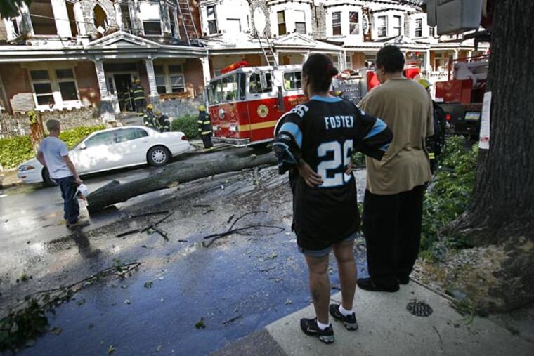 From across the street, neighborhood residents look at the fire scene on the 1400 block of North 55th Street in West Philadelphia.