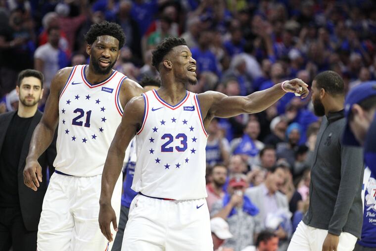 Joel Embiid, left, and Jimmy Butler of the Sixers celebrate as the Raptors call a timeout during the 2nd half of their NBA playoff game at the Wells Fargo Center on May 2, 2019.
