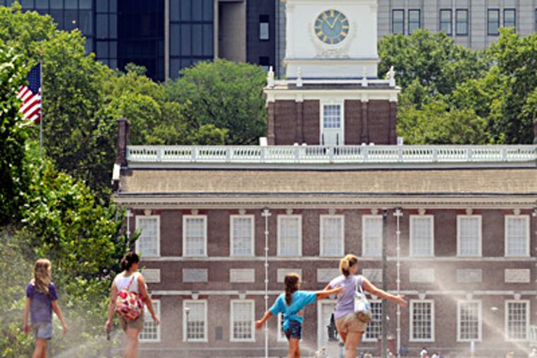 Cooling off in the midst of the mist of lawn sprinklers, visitors to Independence Mall get a bit of relief from the heat wave that has smothered the Philadelphia region for more than a week. TOM GRALISH / Staff Photographer