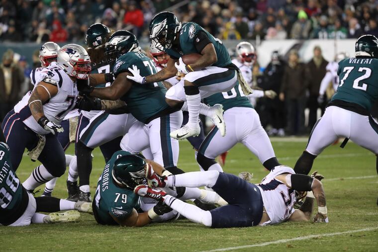 Eagles running back Miles Sanders (26) hurdles over the New England Patriots defense during the second quarter of the game at Lincoln Financial Field on November 17, 2019.