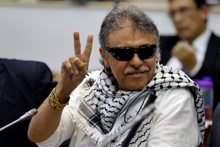 FILE - In this June 12, 2019 file photo, former FARC rebel Jesus Santrich gives a victory signal to journalists as he attends a session of the Chamber of Representatives at the Colombian congress in Bogota, Colombia. United Nations workers assisting in Colombia’s peace process said Monday, July 1, that Santrich, who's real name is Seuxis Hernandez has gone missing, raising concerns for his safety. (AP Photo/Fernando Vergara, File)