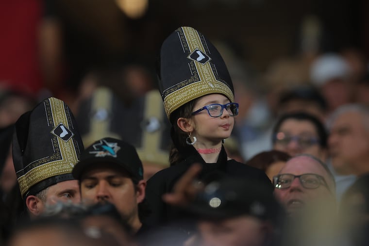 A fan wears a promotional pope hat during a baseball game between the Cincinnati Reds and Chicago White Sox, Tuesday, Aug. 11, 2026, in Chicago.