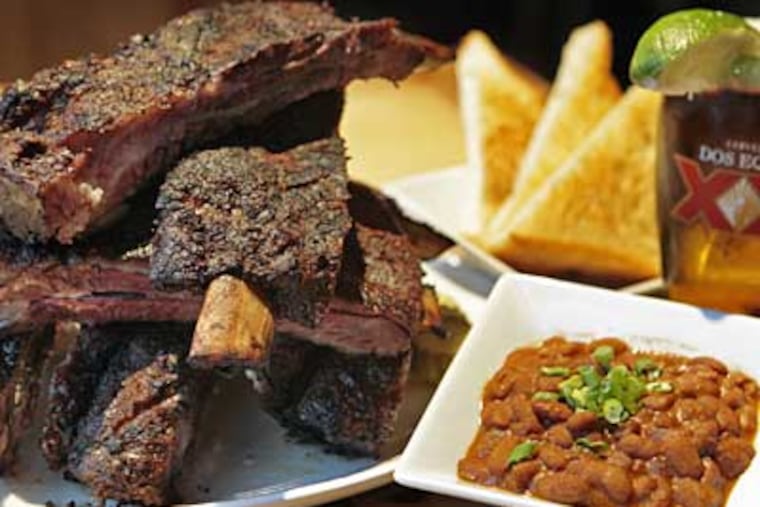 The beef ribs, brontosaurus big and clinging to a twisty char of spice-crusted flesh and fat, are almost a reason in themselves to visit. (Elizabeth Robertson / Staff Photographer)