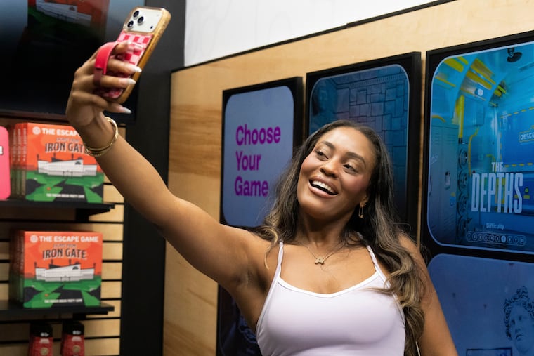 Phoenix-based content creator Aiesha Beasley films herself at the Escape Game in Gilbert, Ariz., Aug. 13, 2026. She said programs such as Arizona State University's could teach transferable skills in fields such as communications and marketing.