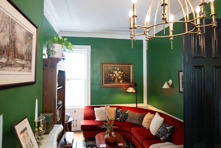 A large red couch is the centerpiece of the first-floor living area in Charlotte Burns and Noah Johnson’s home.