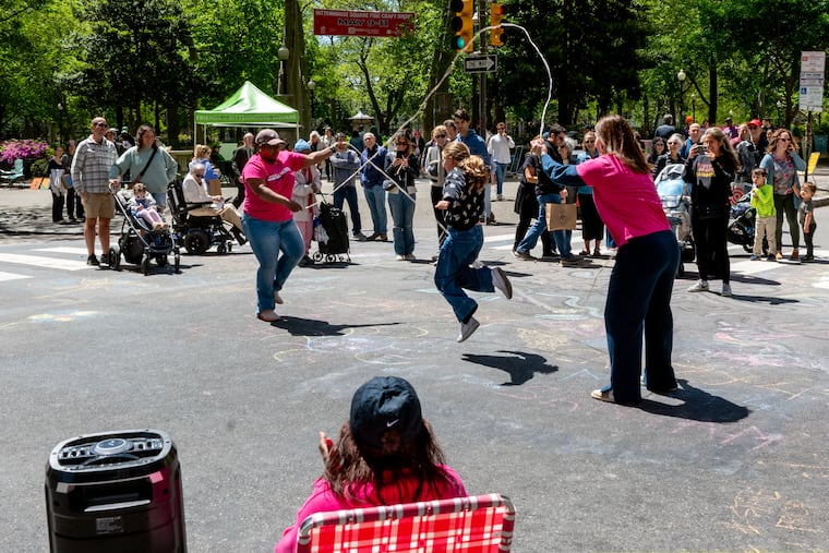 Ten year-old Gabi Flaum jumps double-dutch with the group Philly Girls Jump along Walnut Street during the final car-free Open Streets of the spring Sunday, Apr. 27, 2025. Flaum was visiting Philadelphia for the weekend with her parents and sister from New York City. Gabi learned double-dutch three years ago at the BedStuy Walls mural festival in Brookyn’s Bedford Stuyvesant neighborhood. The Center City District takes space usually used by cars and trucks and gives it over to pedestrians every spring near Rittenhouse Square — 18th Street from Locust to Chestnut Street and Walnut from 15th to 19th Streets. On the ropes are Rasheedah McLean (left) and Katie Motyka (right) with Philly Girls Jump, a group founded in April 2016 as an idea between two friends to post a Facebook event turned into a meetup that attracted hundreds of jumpers attended. The group has met since then, even through the pandemic, and last spring City Council recognized them and declared May 4 and every future first Saturday in May as “Philly Double Dutch Day” in the city.