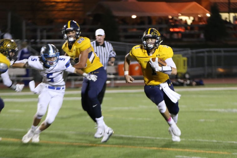 Unionville’s Joe Zubillaga (1) looks for running room in a 41-14 win over Ches-Mont League American Division rival Great Valley.