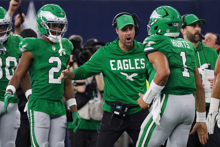 Eagles quarterback Jalen Hurts returning to the bench and celebrating with offensive coordinator Kevin Patullo on Sunday.