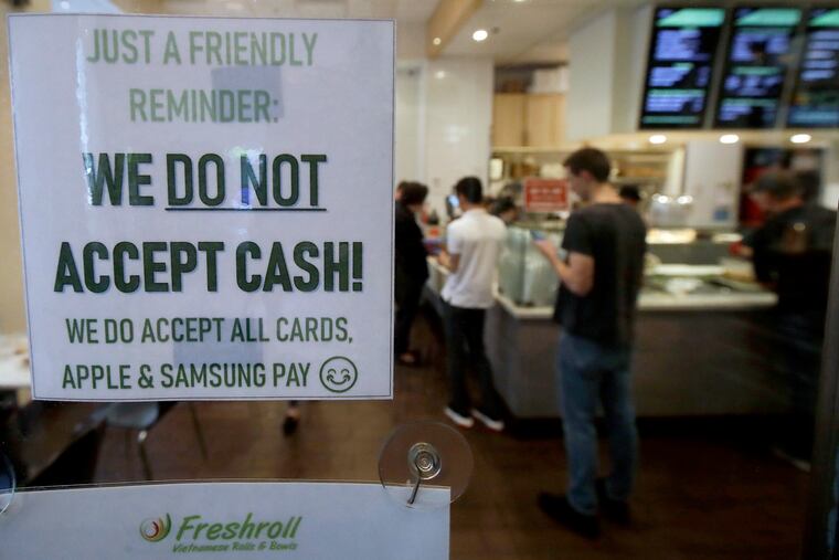 This Thursday, May 2, 2019, photo shows a sign posted on a door alerting customers that cash is not accepted at Freshroll Vietnamese Rolls and Bowls in San Francisco. San Francisco is about to require brick-and-mortar retailers to take cash in payment for goods, joining Philadelphia and New Jersey in banning a practice that critics say discriminates against the poor.