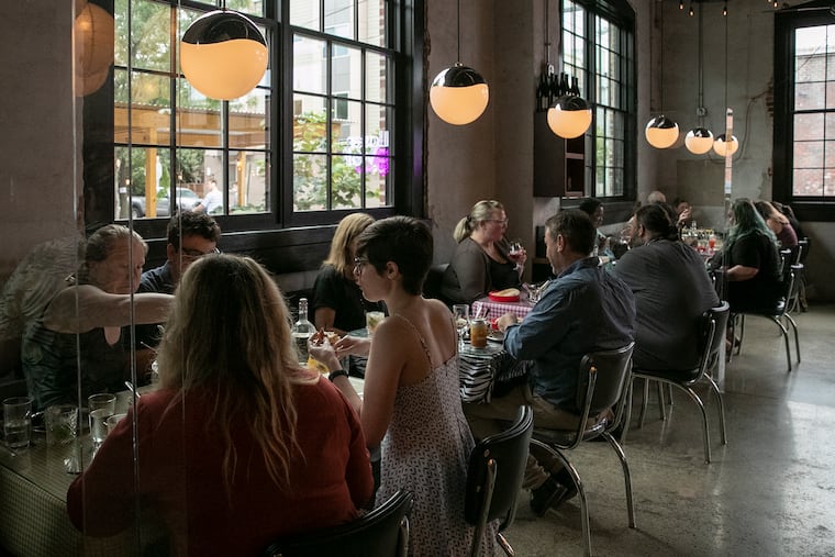 People dine at Laser Wolf this summer. Philadelphia is considering a vaccine mandate for indoor dining.