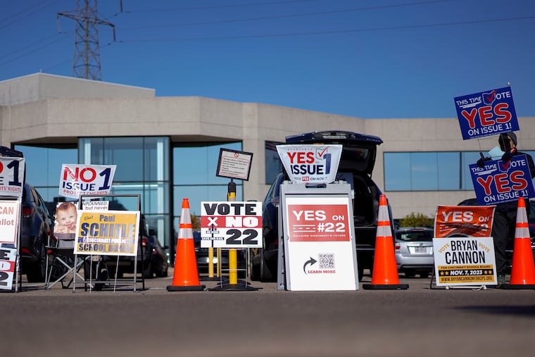 People gather in the parking lot of the Hamilton County Board of Elections as people arrive for early in-person voting in Cincinnati last week. They urge people to vote for or against different issues, including the measure known as Issue 1. Issue 1 is the only abortion question on any state ballot this year.