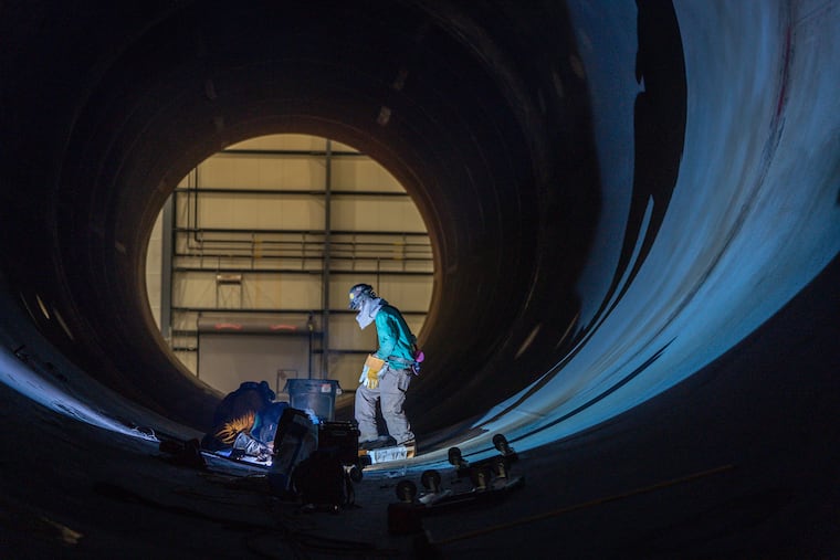 Welders at work on a monopile foundation at EEW American Offshore Structures in Paulsboro in 2023.
