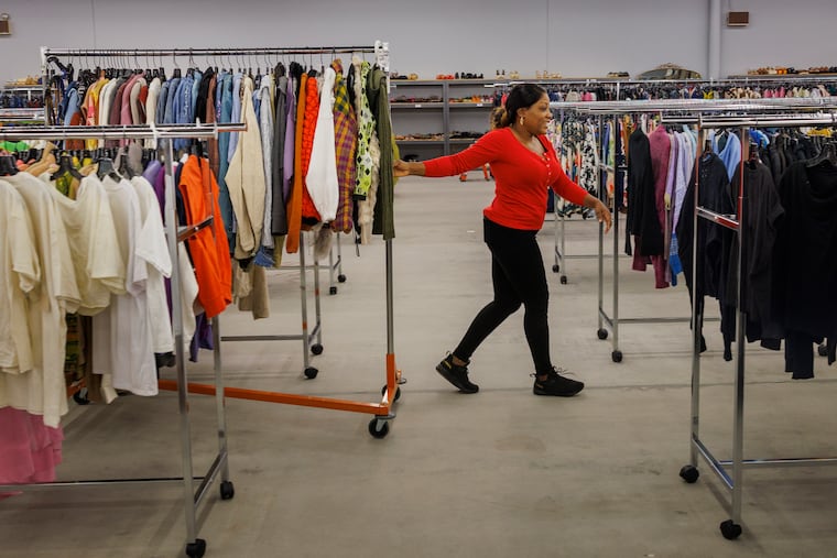 A sales associate at Reclectic pulling a rack of clothing at the Franklin Mall location on Thursday, August 10, 2023.