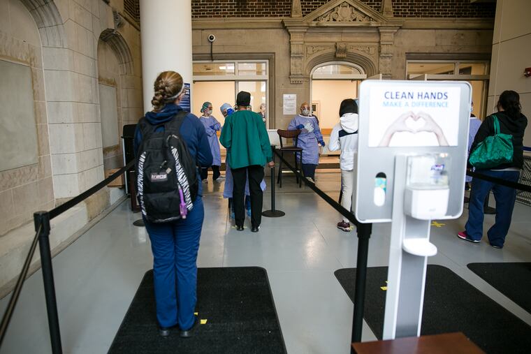 Employees are temperature scanned as they enter the Hospital of the University of Pennsylvania. With the right safety precautions, allowing hospital visits can promote patients' health by connecting them to their primary caretakers, write Amol S. Navathe and Joshua M. Liao.