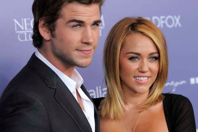 Actor Liam Hemsworth, left, an honoree at the Australians in Film 8th Annual Breakthrough Awards, poses with his fiance Miley Cyrus on the red carpet on Wednesday June 27, 2012, in Los Angeles. (Photo by Chris Pizzello/Invision/AP)
