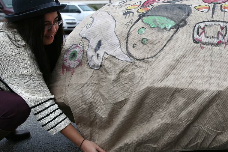 Artist Holiday Campanella adjusts the car cover she designed for the EmpireCover Halloween Car Cover Contest in Philadelphia on October 23, 2014. ( DAVID MAIALETTI / Staff Photographer )