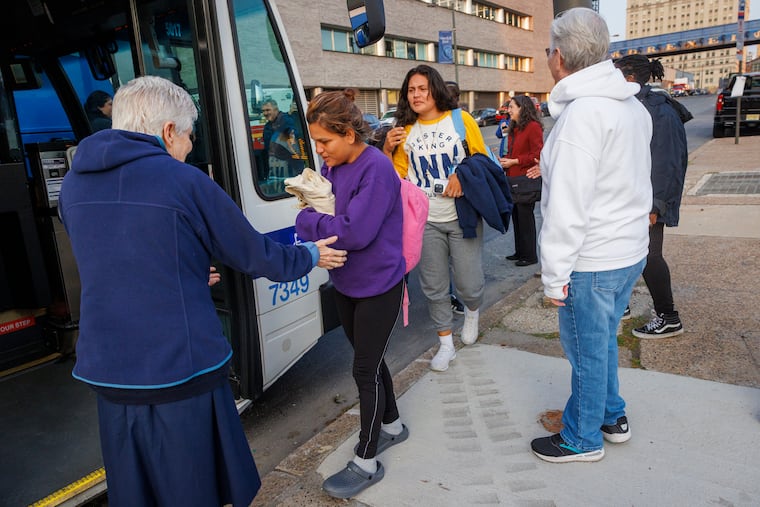 Sisters Eileen Reilly, of Immaculate Heart of Mary, and Pat Madden, of St. Joseph's, greet a group of immigrants who arrived by bus to Philadelphia, where they were met by the Office of Emergency Management and other organizations on JFK Boulevard just west of 30th Street Station, early in the morning, May 10, 2023.
