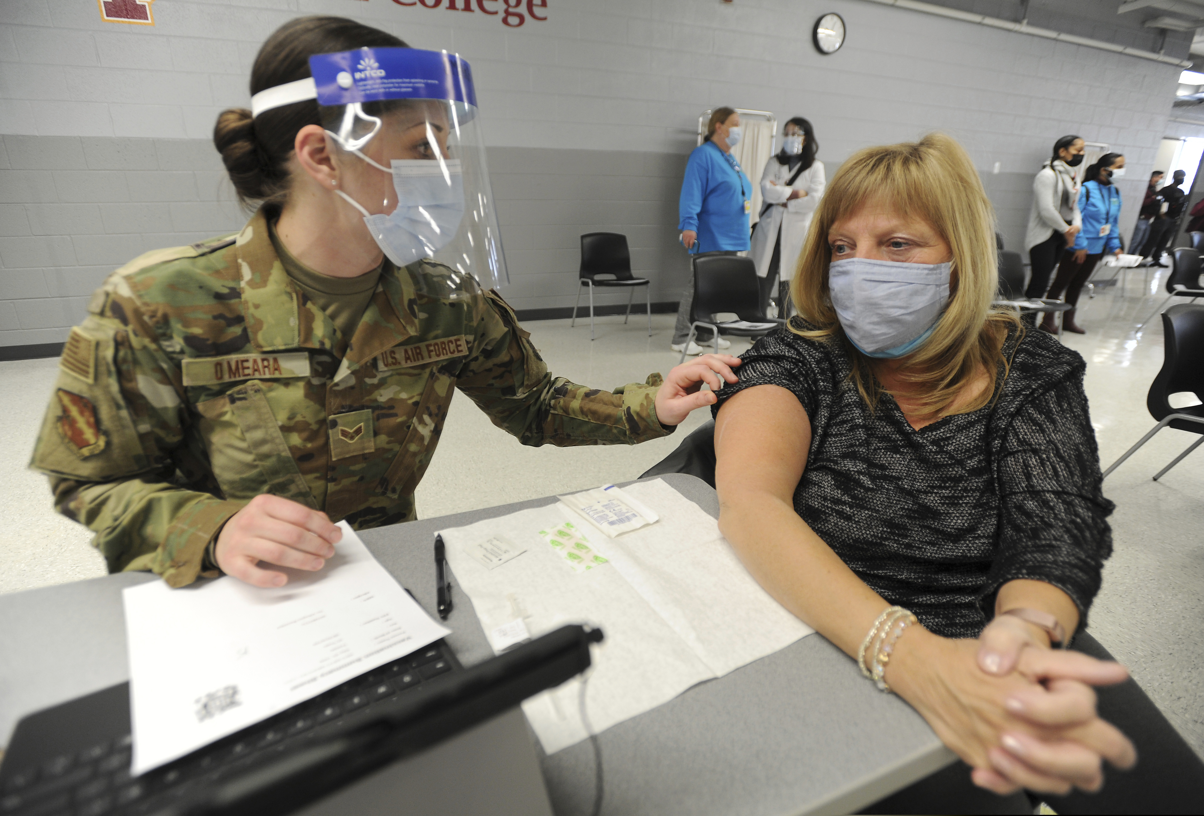 Lisa Meincke of Arlington Heights prepares herself to receive her first COVID-19 vaccination administered by National Guard personal Erika O'Meara of Scott Air Force base at Triton College, Wednesday, Feb. 3, 2021, in River Grove, Ill. This was opening day for the mass vaccinations sponsored by the Cook County Department of Public Health.