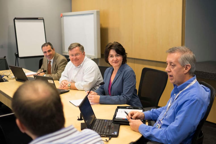 Jerry Cederlund (right), ARRIS Group senior vice president of business operations, leads a meeting at the company's offices in Horsham.