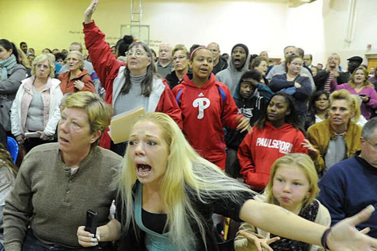 Kristin Medlin erupts at a meeting in Gibbstown over responses to the derailment in Paulsboro while sitting with her mother, Suzanne Blankley, and daughters. Residents were frustrated over the handling of evacuations. (Clem Murray/Staff)