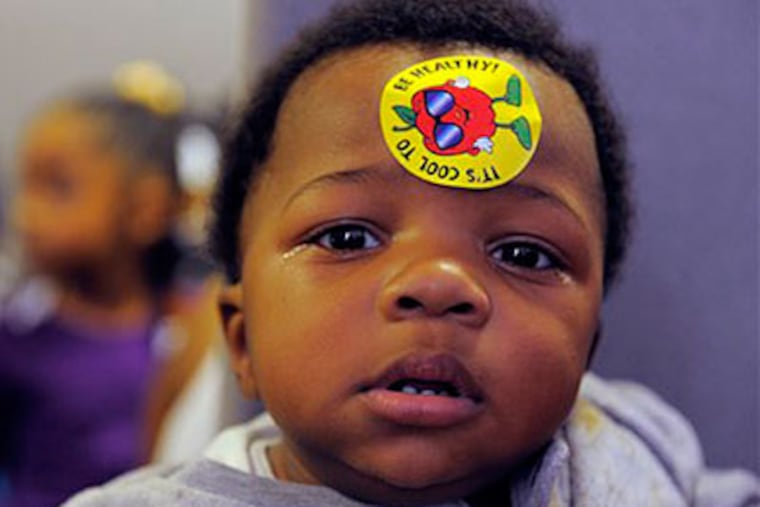 Timothy Cammon, 2, of Detroit sports a "It's Cool to be Healthy," sticker after receiving the H1N1 vaccine during a Detroit Public Health Dept distribution of the H1N1 flu vaccine. (AP Photo/Detroit News, Steve Perez)