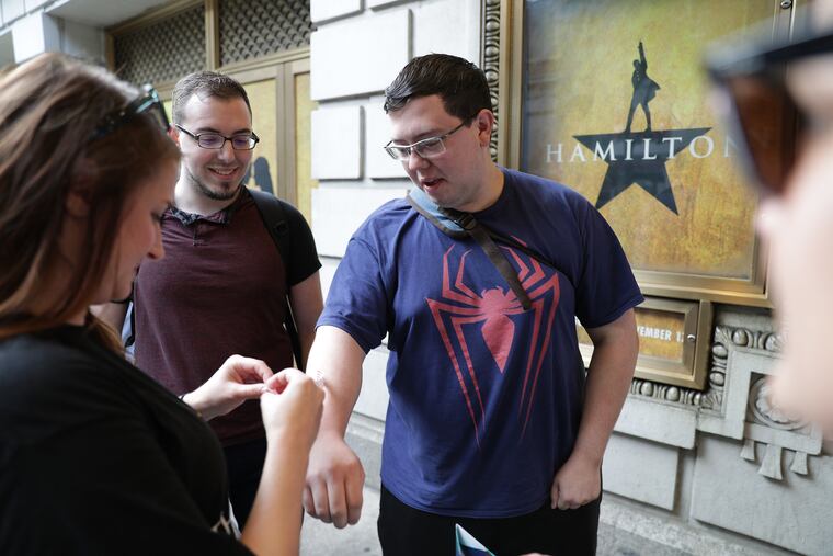 Mike Bradley, right, 26, of Northeast Philadelphia, was the first in line Tuesday to receive a wristband to purchase Hamilton tickets on the first sale date. He arrived at midnight with his friend, Howard Stickley, 24, at left. As of Wednesday afternoon, tickets were still available, no wristband required.