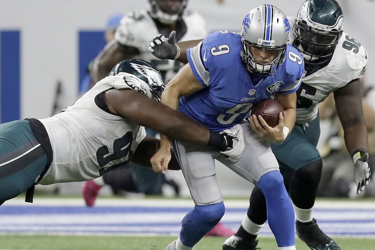Eagles' defensive tackle Fletcher Cox and defensive tackle Bennie Logan go after Detroit Lions' quarterback Matthew Stafford on Sunday, October 9, 2016 in Detroit. YONG KIM / Staff Photographer