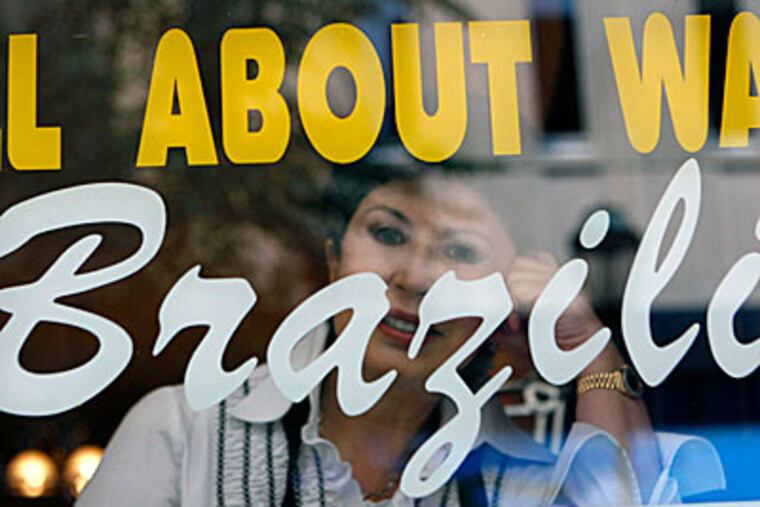 Emma Sherby looks out through the window of the International Salon, on Sansom Street. A Brazilian bikini wax is "an art," she says. "Not everybody can do." (Bonnie Weller / Inquirer)