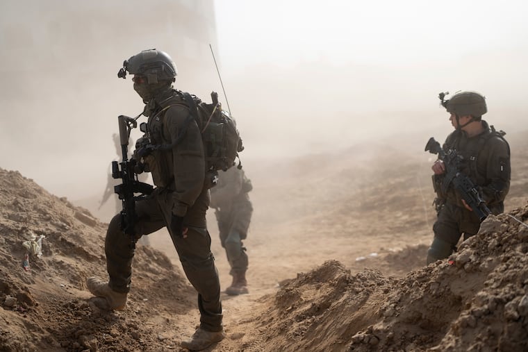 Israeli soldiers take up positions during a ground operation in Khan Younis, Gaza Strip, on Wednesday. The Israeli military strategy so far has apparently been to destroy Gazan infrastructure with abandon, writes Trudy Rubin.