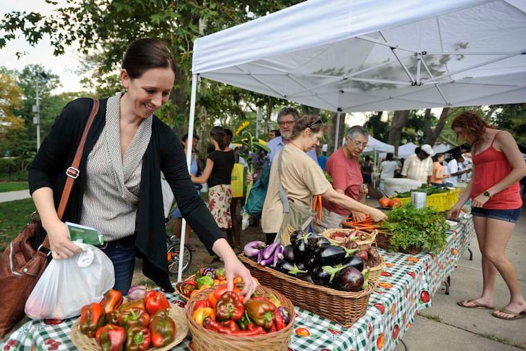 Joani Walsh, a USDA undersecretary , looks over vegetables at Clark Park Farmers' Market in West Philadelphia. "Philly's just really been out in front with some groundbreaking work," she said. RON TARVER / Staff Photographer