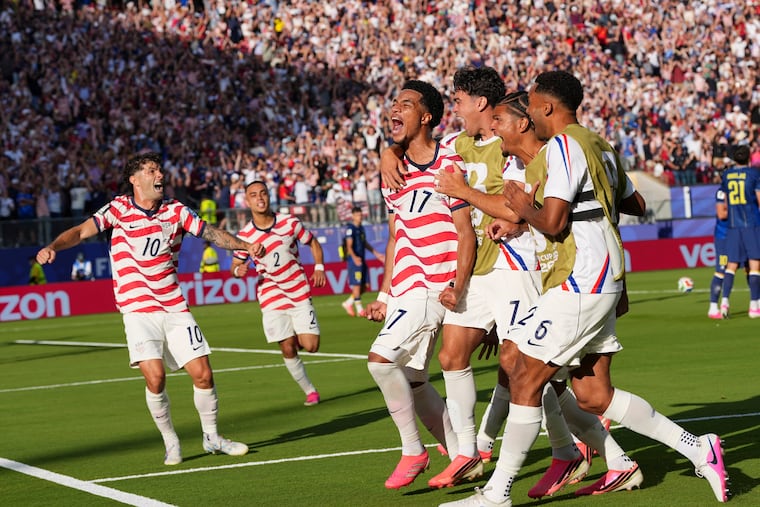 Malik Tillman (center) celebrates with teammates after scoring the free kick goal that sealed the U.S. men's soccer team's win over Bosnia and Herzegovina.