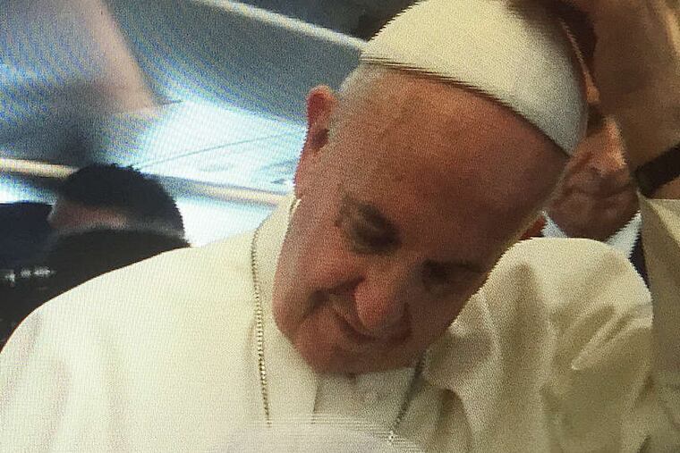 Pope Francis tries on O'Reilly's zucchetto before handing it back. It was a little big, the pontiff said.