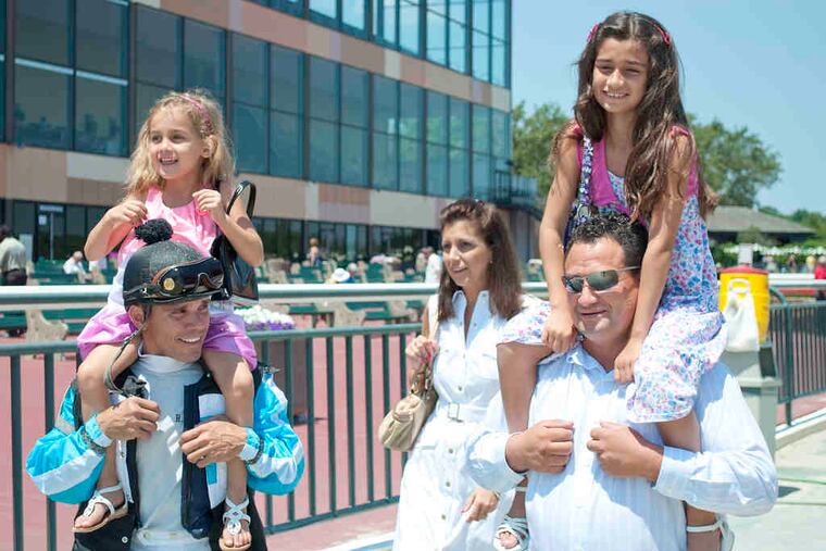 Carlos Guerrero (right) carries daughter Isabella, while jockey Roberto Alvarado carries Julianna followed by Guerrero's wife, Lisa.