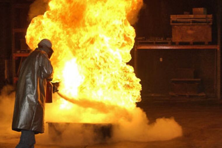 Kris Inselberger tests a dry chemical fire extinguisher at Underwriters Laboratories in Northbrook, Illinois, in April 2003. (Jim Robinson / Chicago Tribune)