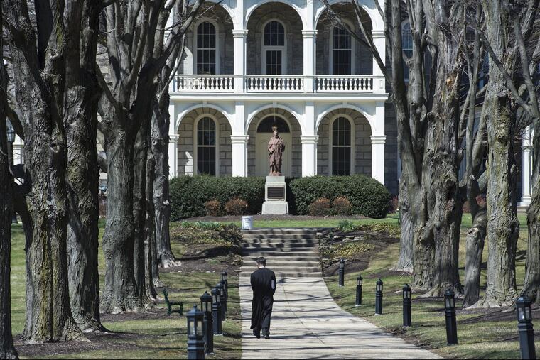 A seminarian at St. Charles Borromeo Seminary in Wynnewood strolls the walkway to the Theology Building.