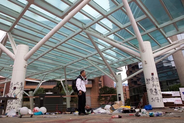 Professor Alex Wai, Vice President of the Polytechnic University, takes in the vandalized campus as he leads a team of school officials and first aid providers to look for holed up protesters on a roof top of the campus in Hong Kong, Tuesday, Nov. 26, 2019.