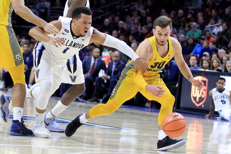 Jalen Brunson, center, of Villanova loses the ball as he gets trapped between Theo John, left, and Andrew Rowsey of Marquette during the 1st half at the Wells Fargo Center on Jan 6, 2018. CHARLES FOX / Staff Photographer