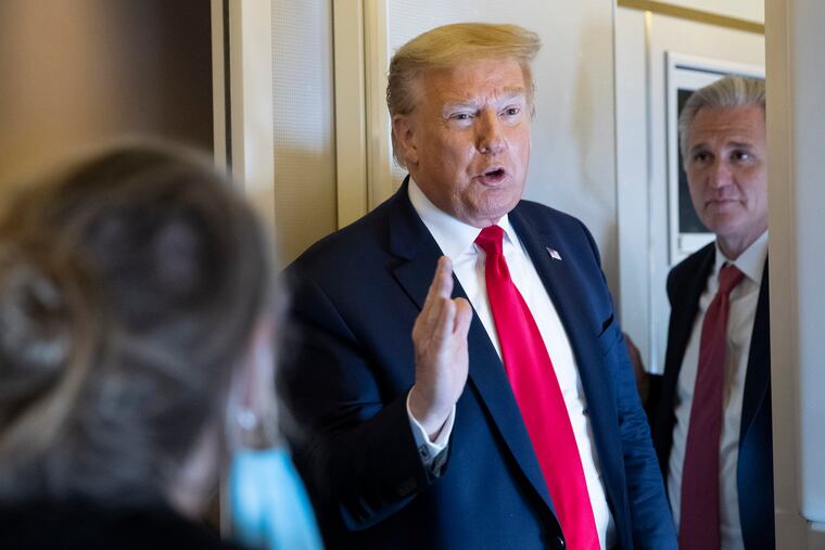 President Donald Trump (center) with House Minority Leader Kevin McCarthy of California (right) speaks with reporters while in the air en route to Andrews Air Force Base on Saturday.
