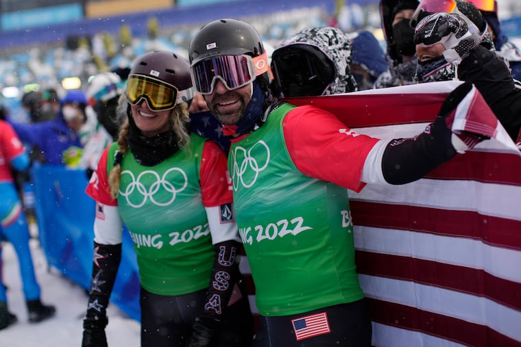 Lindsey Jacobellis (left) and Nick Baumgartner celebrate after winning gold in the mixed team snowboard cross finals at the Winter Olympics in Beijing.
